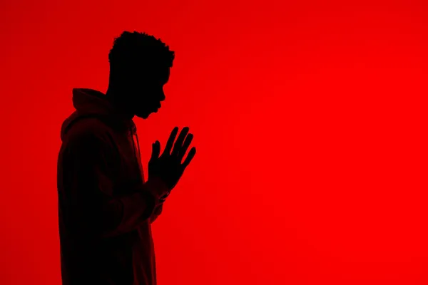 Boční Pohled Siluetu Nepoznatelného Afroameričana Stojícího Sepjatýma Rukama Modlícího Červeném — Stock fotografie