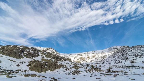 日中は曇り空の下 田舎の雪に覆われた険しい岩山の絵のような風景 — ストック写真