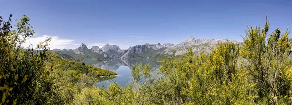 スペインのレオンで青い空と晴れた夏の日に岩の山と緑の木々に囲まれたリアーノ貯水池の絵のようなパノラマの風景 — ストック写真