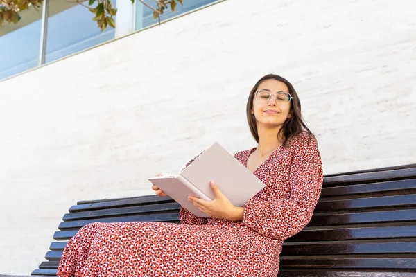 Positive Junge Frau Stilvoller Kleidung Sitzt Mit Aufgeschlagenem Buch Auf — Stockfoto