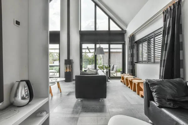 玻璃门附近装饰有舒适沙发的时髦宽敞的灰色客厅的内部 — 图库照片