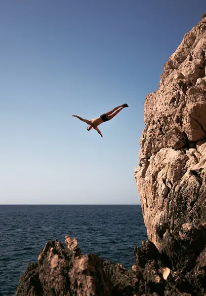 Atleta Masculino Activo Bañador Saltando Del Monte Mar Bajo Cielo — Foto de Stock