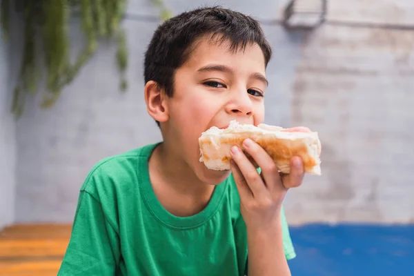 Ragazzo Abbigliamento Casual Guardando Fotocamera Mentre Prende Morso Fresco Gustoso — Foto Stock