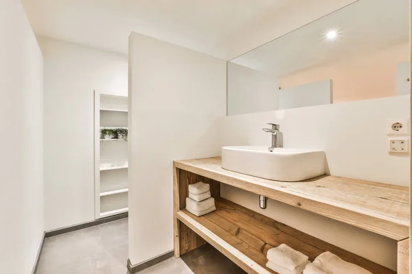 鏡と木の棚の間に洗面台付きバスルームの創造的なデザイン光沢のあるランプと家の中のタオル — ストック写真
