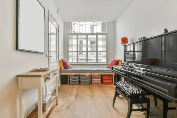 空旷的当代房间 木制地板 黑色钢琴 白天装饰着五彩缤纷的垫子和储物柜 — 图库照片
