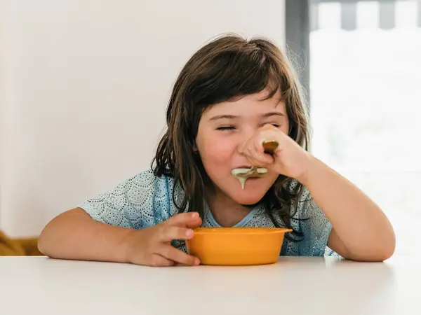 Adorable Child Eating Delicious Cream Soup Plastic Bowl While Sitting — Stock Photo, Image