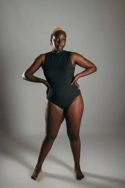 Allvarlig Afroamerikansk Kurvig Kvinna Svart Bodysuit Står Med Händerna Höfterna — Stockfoto