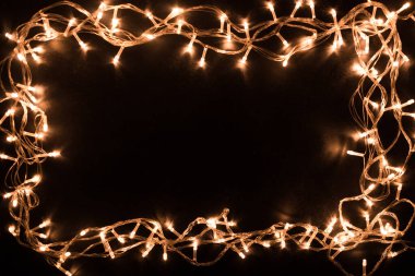 Noel ışıkları sınırda. Işıklı ve bedava metin alanlı bir Noel arkaplanı. Siyah arka planda Noel ışıkları. Yeni Yıl.