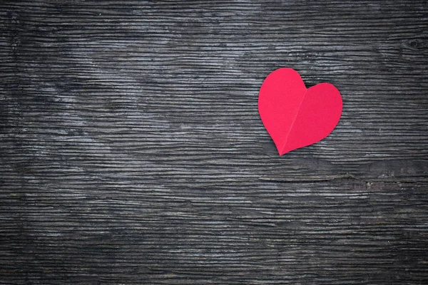 O coração vermelho de um papel está em uma velha tábua — Fotografia de Stock