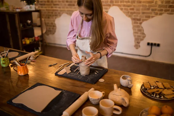 Menina esculpe um jarro de barro em uma cerâmica. — Fotografia de Stock