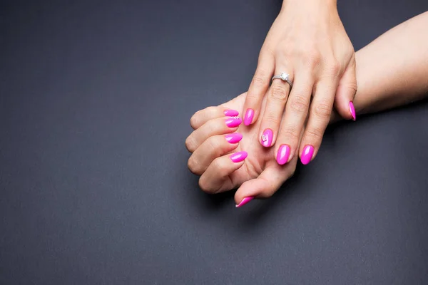 Manicure elegante rosa em um fundo preto — Fotografia de Stock