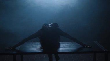 Seksi bir kızın silueti mavi dumanla erotik bir dans ediyor..