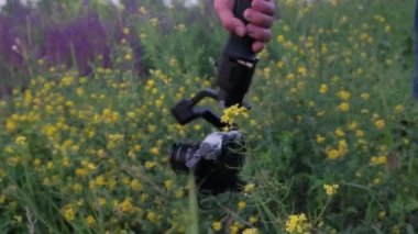 Kiev, Ukrayna - 27 Haziran 2020: Bir adam elinde bir dengeleyiciyle bir kamera tutuyor ve doğanın fotoğraflarını çekiyor.