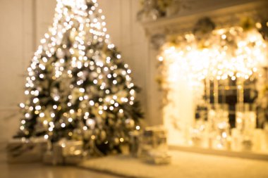 Arka plan bulanık. Parlak bir odada üç zarif Noel ağacı. Yeni Yıl ve Noel