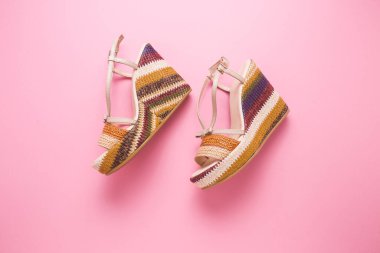 Pembe arka planda kadın sandaletleri..