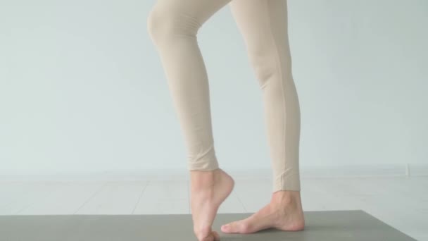 Una mujer estira las piernas antes de un primer plano de clase de yoga. — Vídeos de Stock