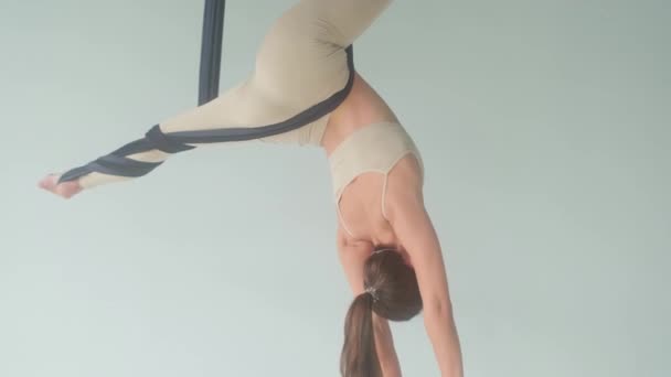 Jeune femme faisant des exercices sur un hamac dans un cours de yoga. — Video