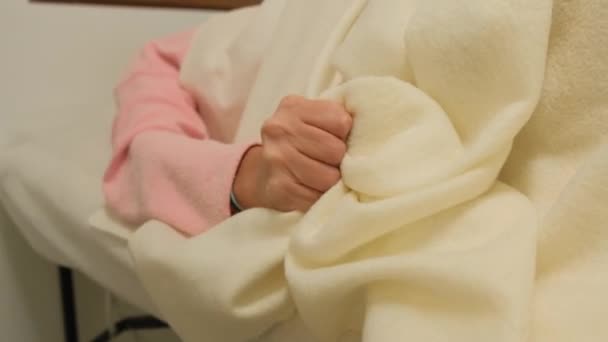 Вагітна дівчина народжує. Жінка має скорочення, і вона тримається на ліжку з її рукою крупним планом — стокове відео