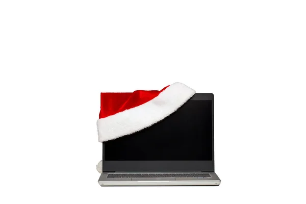 Laptop em um fundo isolado branco. Um chapéu de santaclaus está em um laptop. O fim do ano de trabalho. Vendas de férias . — Fotografia de Stock