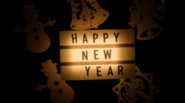 - Mutlu yıllar. Karanlık bir arkaplanda yazı olan Noel ışıkları.