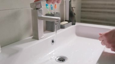 Bir adam ellerini yıkar ve su geçirmez akıllı bir saati ıslatır..