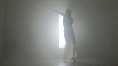 Bachata yapan kadın dumanla içeride dans ediyor..