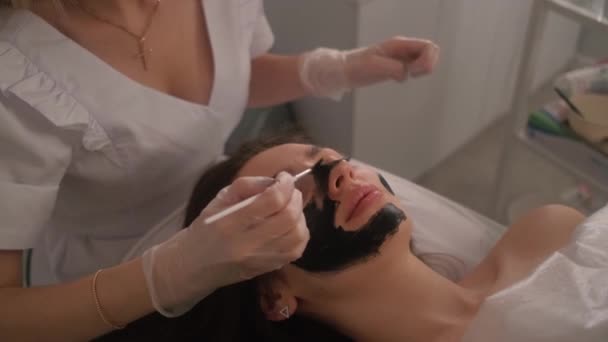 Kohlenstoff-Peeling des Gesichts eines jungen schönen Mädchens. Kosmetik der Haut. Lasertherapie und Hautbehandlung. — Stockvideo
