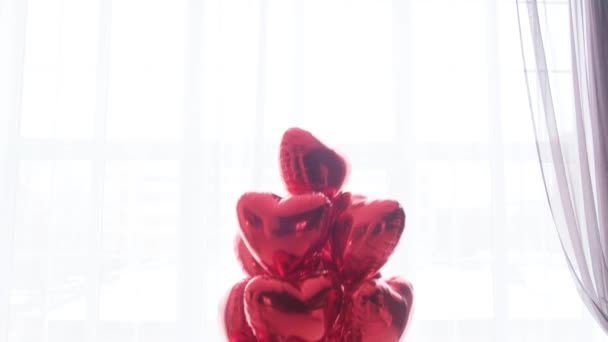 Yüzen bir buket kırmızı, beyaz arka planda kalp şeklinde balonlar.. — Stok video