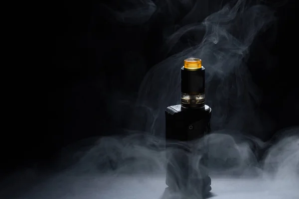 Вейп крупним планом в диму на чорному тлі — стокове фото