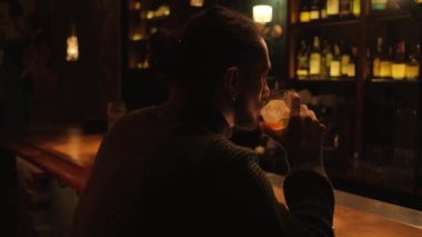 Bir gece barında genç bir adamın portresi. Bir adam kokteyl içer ve barmenle iletişim kurar..