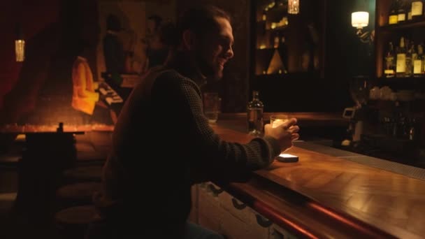 夜のバーで若い男の肖像画。男はカクテルを飲んで休み. — ストック動画