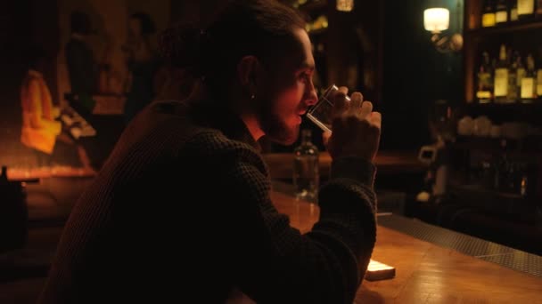Portret młodego faceta w nocnym barze. Mężczyzna pije koktajl i odpoczywa. — Wideo stockowe