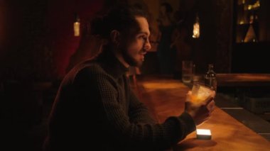 Bir gece barında genç bir adamın portresi. Bir adam kokteyl içer ve barmenle iletişim kurar..