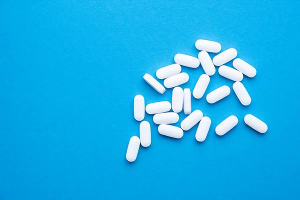 Vita piller på en blå bakgrund närbild. — Stockfoto
