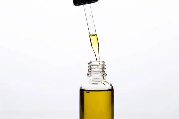 Massage oil in a glass bottle with a pipette on a white isolated background. — Stock Photo, Image