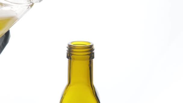 Plantaardige olie wordt gegoten in een fles op een witte achtergrond close-up. — Stockvideo