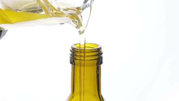 Vegetable oil is poured into a bottle on a white background close-up. — Stock Video