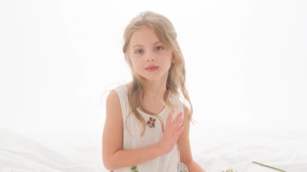 Retrato de una hermosa niña sobre un fondo blanco. — Vídeos de Stock