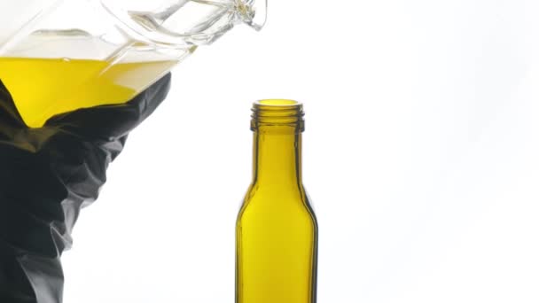 Olej roślinny wlewa się do butelki na białym tle zbliżenie. — Wideo stockowe