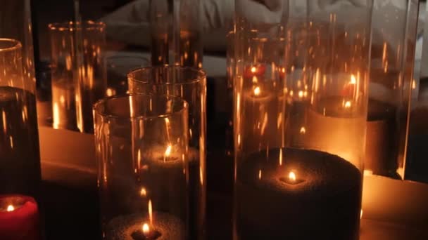 Hermosas velas en un frasco de vidrio. Flickering fuego atmósfera romántica. — Vídeo de stock