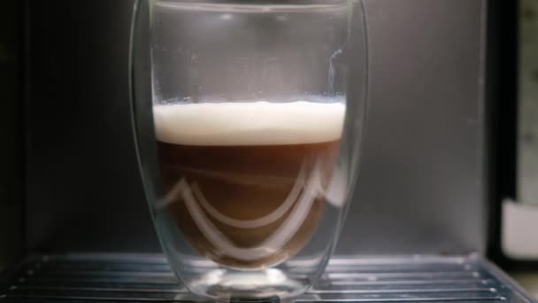 Крупним планом капучино в скляній чашці біля кавоварки . — стокове відео
