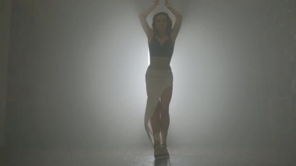 Женщина танцует бачата в помещении с дымом. — стоковое видео
