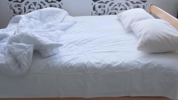 Λευκά λινά στο κρεβάτι σε φωτεινό δωμάτιο κατά τη διάρκεια της ημέρας. — Αρχείο Βίντεο