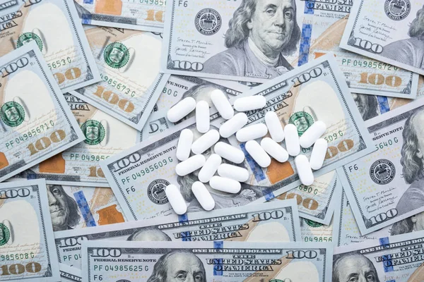 Pills on the background of the dollar close-up. — Stock Photo, Image