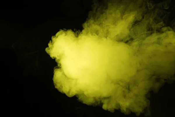 Colorful smoke close-up on a black background. Yellow cloud of smoke. — ストック写真