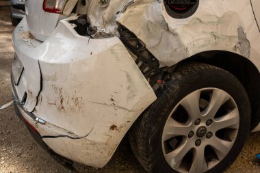 Kazadan sonra beyaz araba. Kırık araba sokakta, yakın plan.