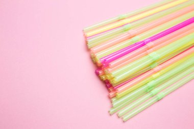 Pembe izole edilmiş arka planda renkli kokteyl pipetleri