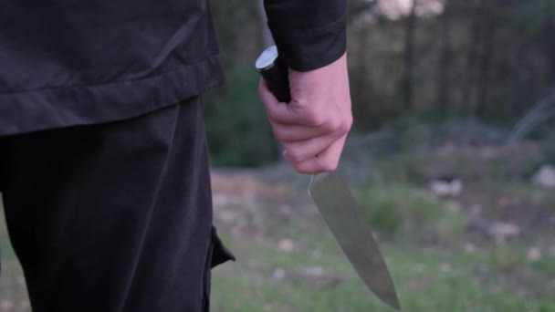 Ormanda bıçaklı bir adam. Manyak, kurbanı takip ediyor ve saldırmaya hazırlanıyor. — Stok video
