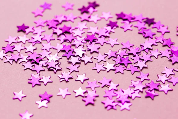 Closeup asterisks sprinkled on a pink isolated background. View from above. — Stock fotografie
