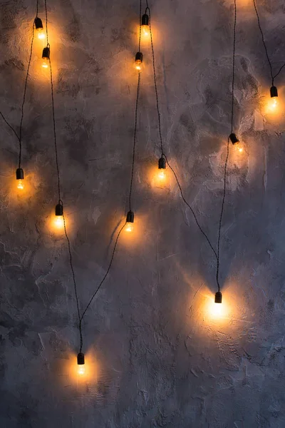Retro bulbs in the form of a garland on a gray concrete background. — Stockfoto